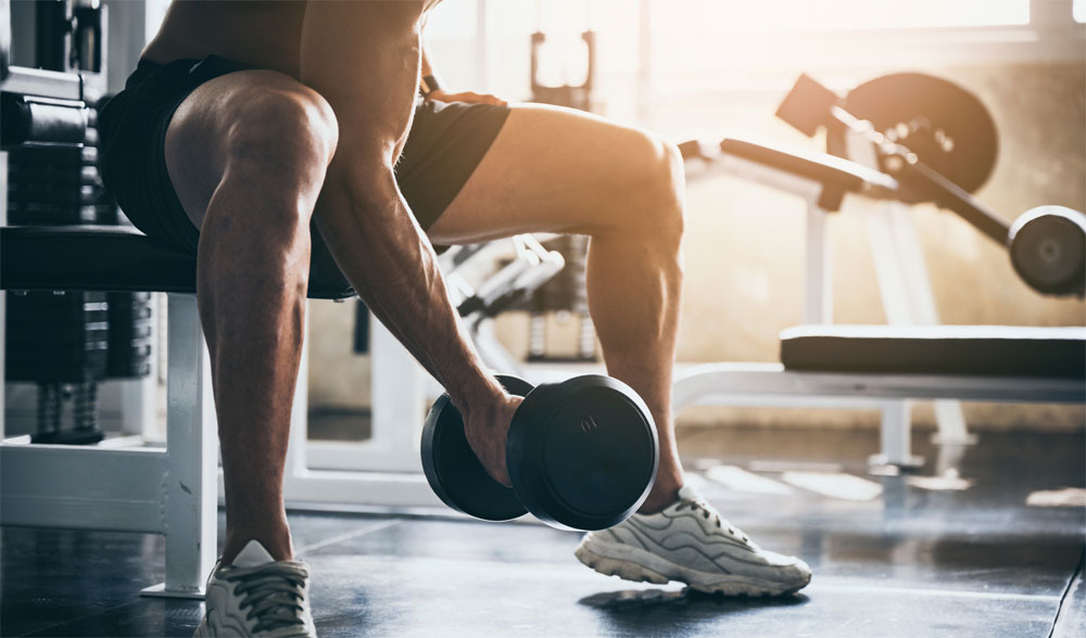 Man lifting dumbbells' in gym for bicep curl workout