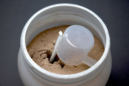 ScoopJack holding scoop in white protein tub chocolate whey protein